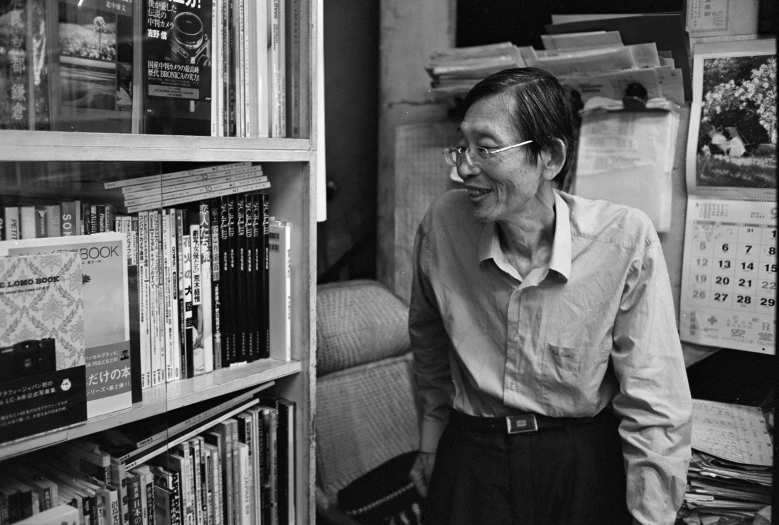 a man standing in front of book shelves full of books