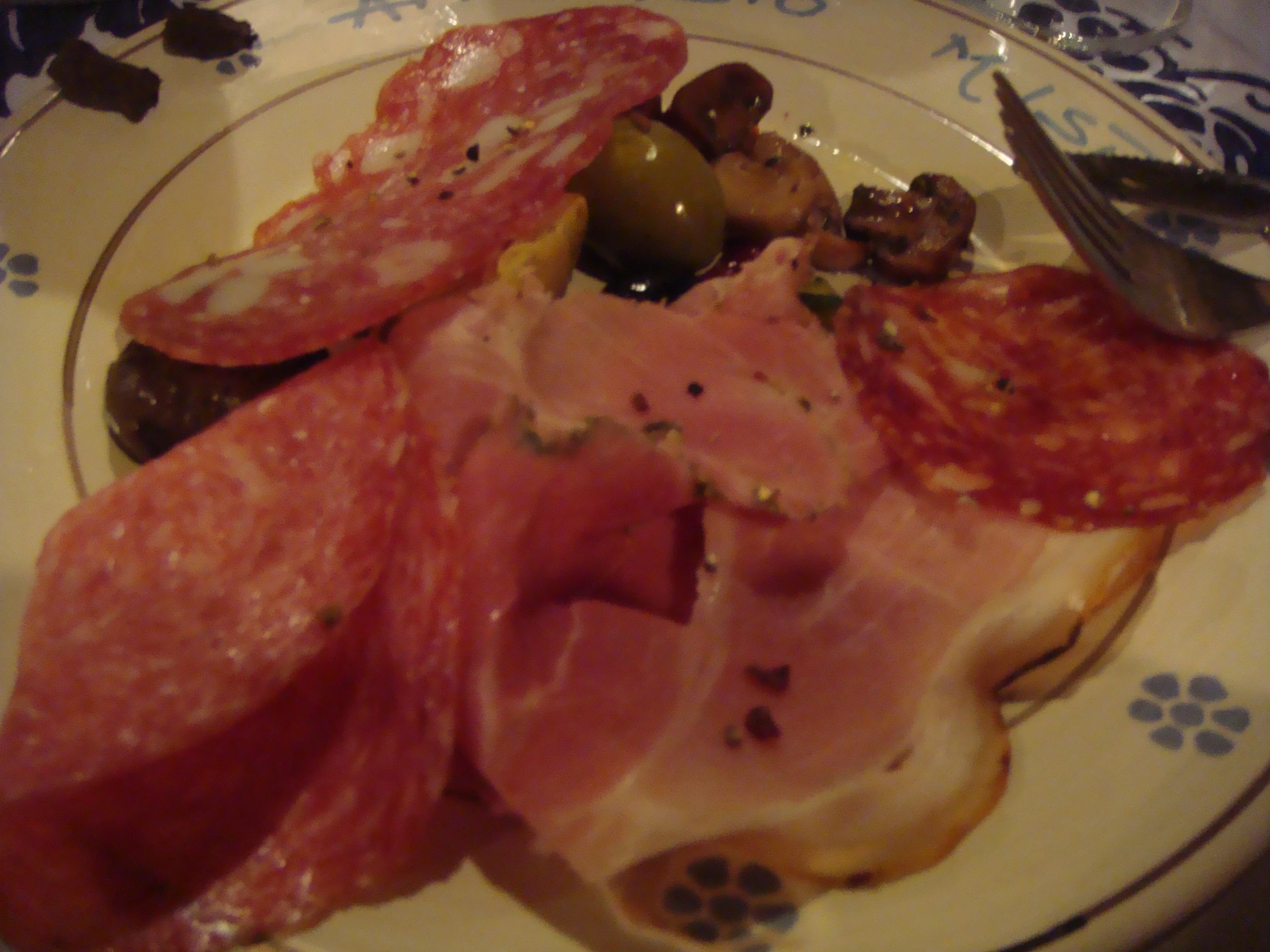 plate with ham, olives, tomatoes and mushrooms on it