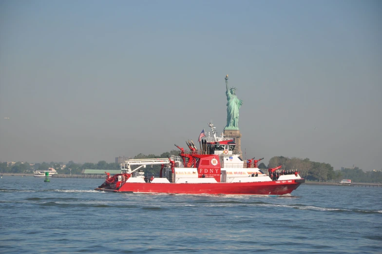 a boat in the ocean with a statue on top