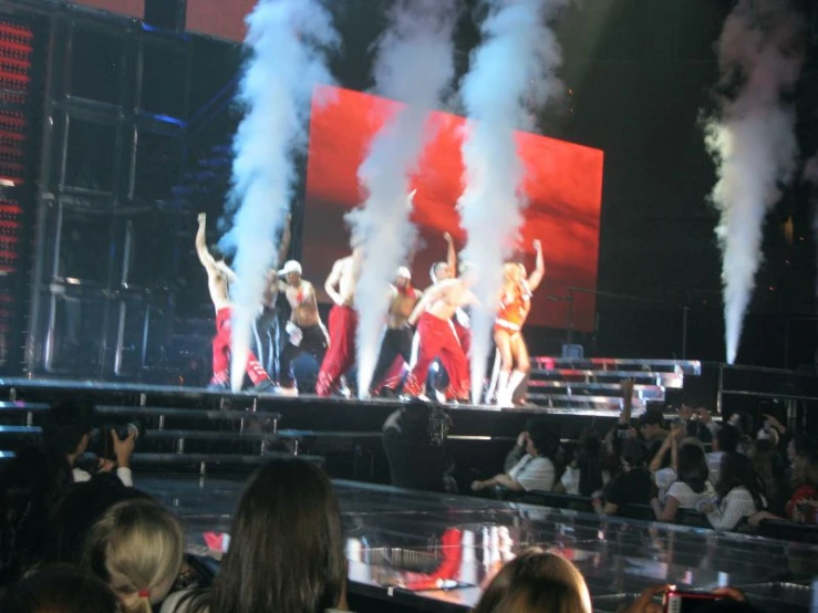 a group of dancers are performing at a music concert