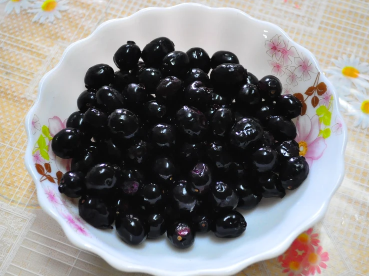 a large bowl filled with blueberries sits on a table