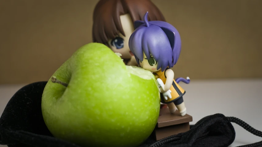 a doll with a black hair holding an apple