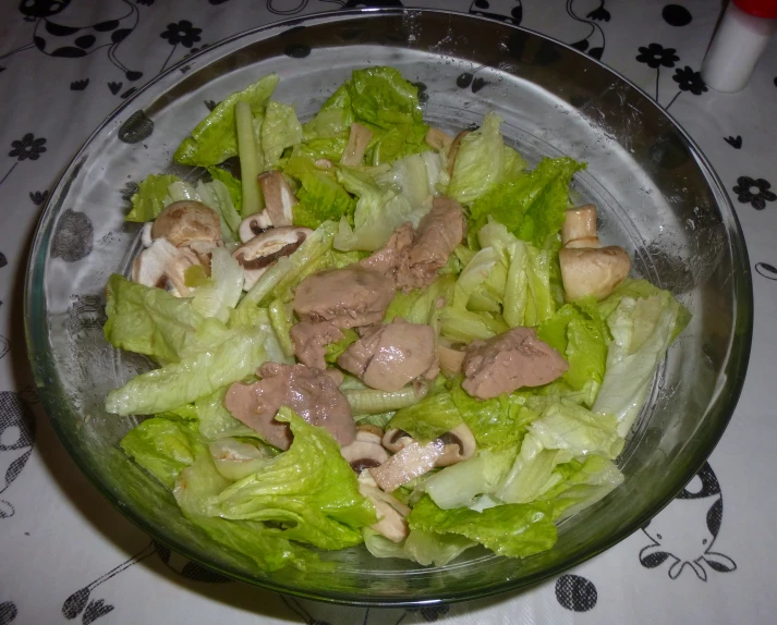 a plate with chopped lettuce, mushrooms, and meat