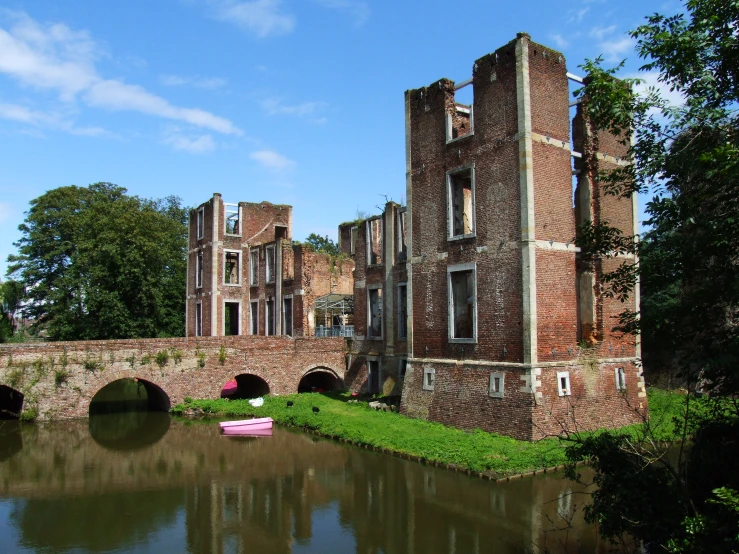 an old building on the water by some bridge