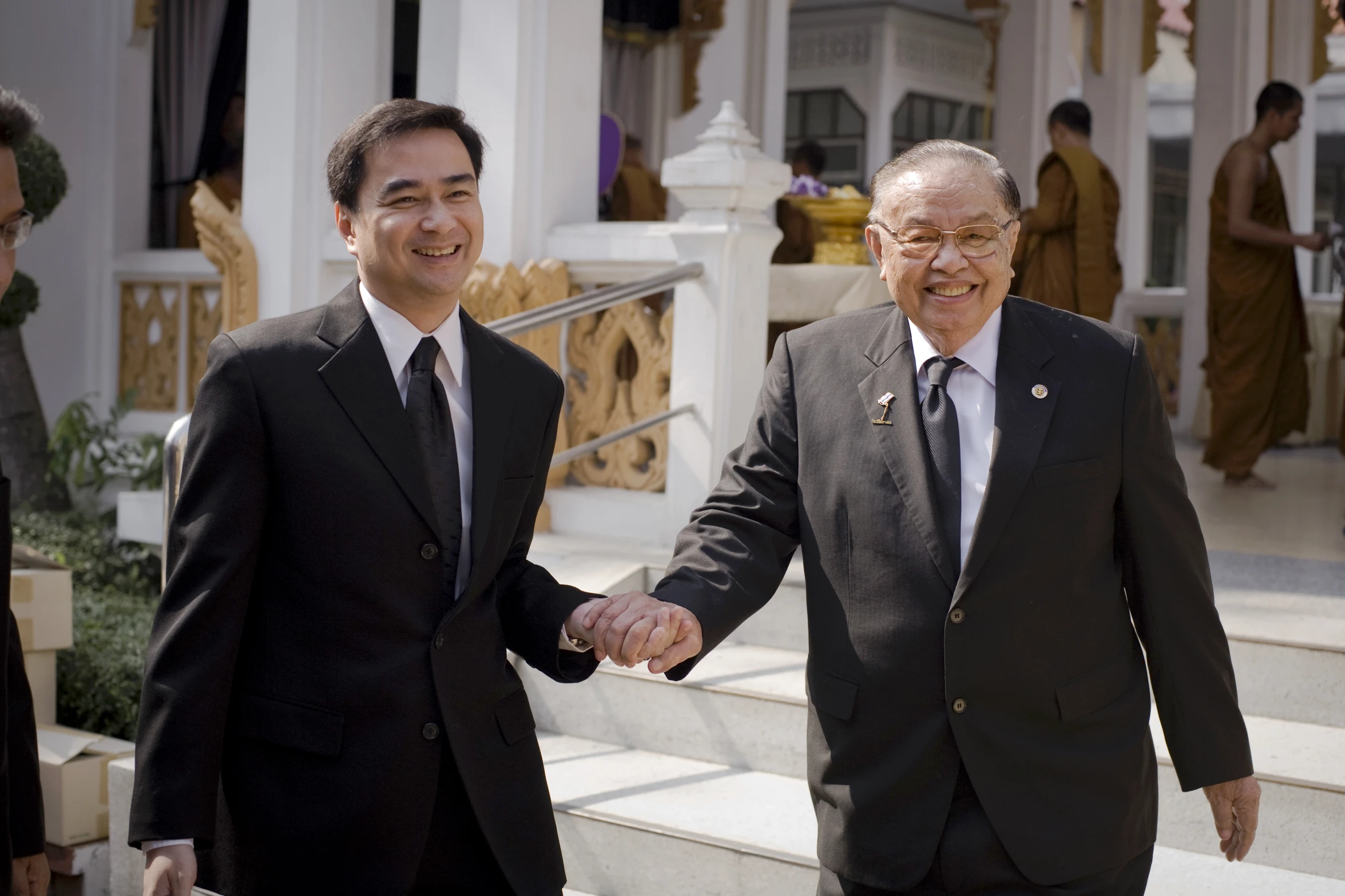 two men are shaking hands near some steps