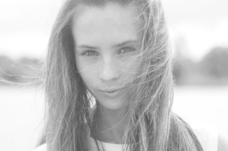 a beautiful young woman posing for a black and white po