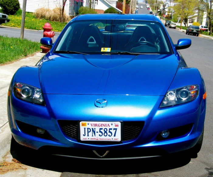 a blue sports car parked on the side of a street