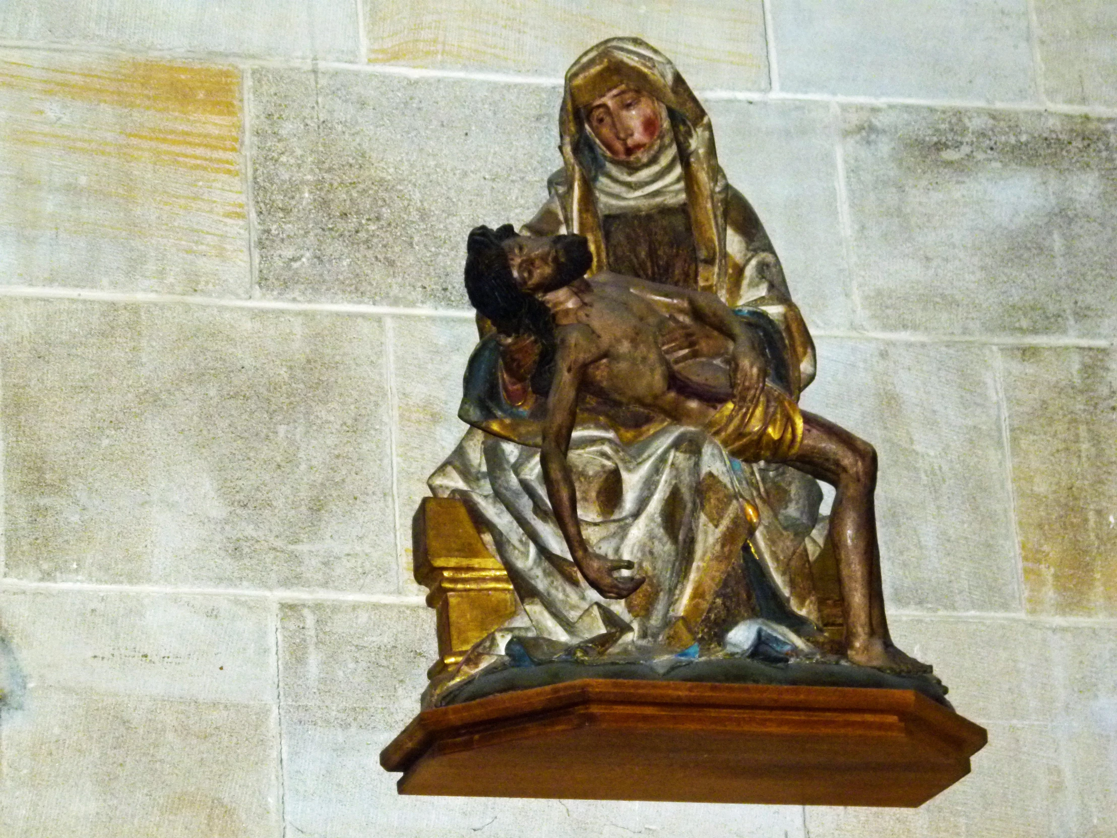 the statue of mary holding the child on top of a church bell