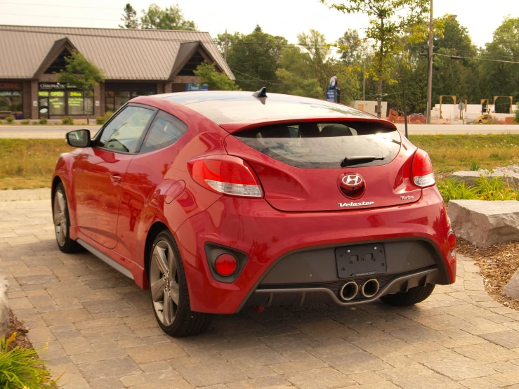 a red car with the hatch lid down and a blue light on it