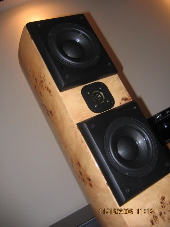 some very large speakers on top of a wooden shelf