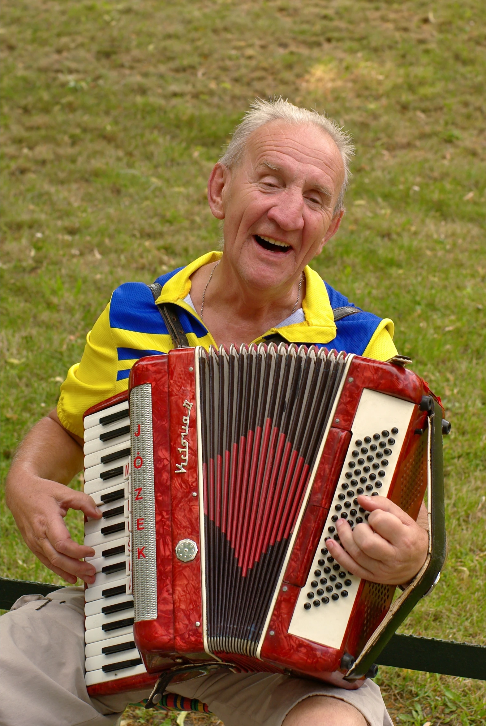 an elderly man is playing an old style accordia