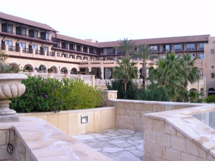 a pool surrounded by buildings with plants growing in it