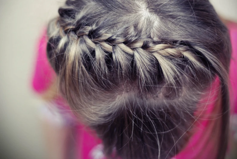 a little girl with long hair wearing a pink shirt