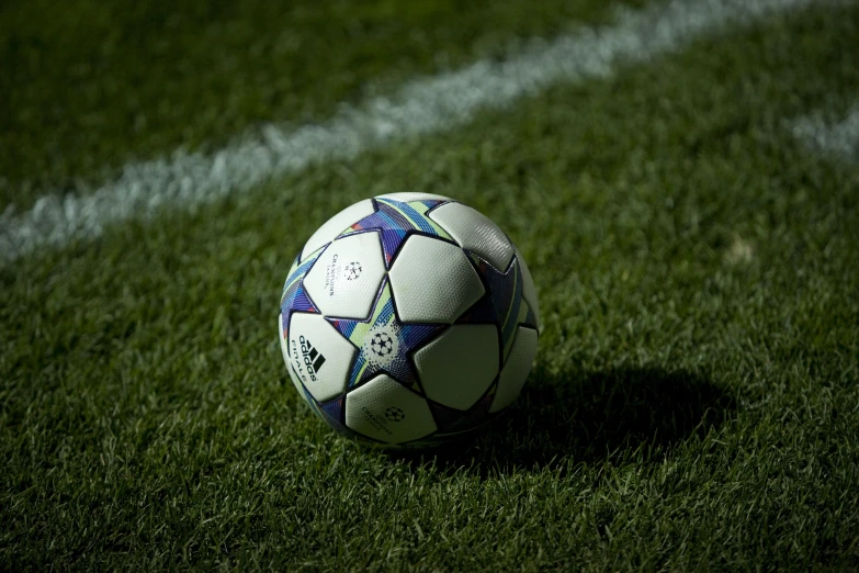 soccer ball on green grass with stripes in background