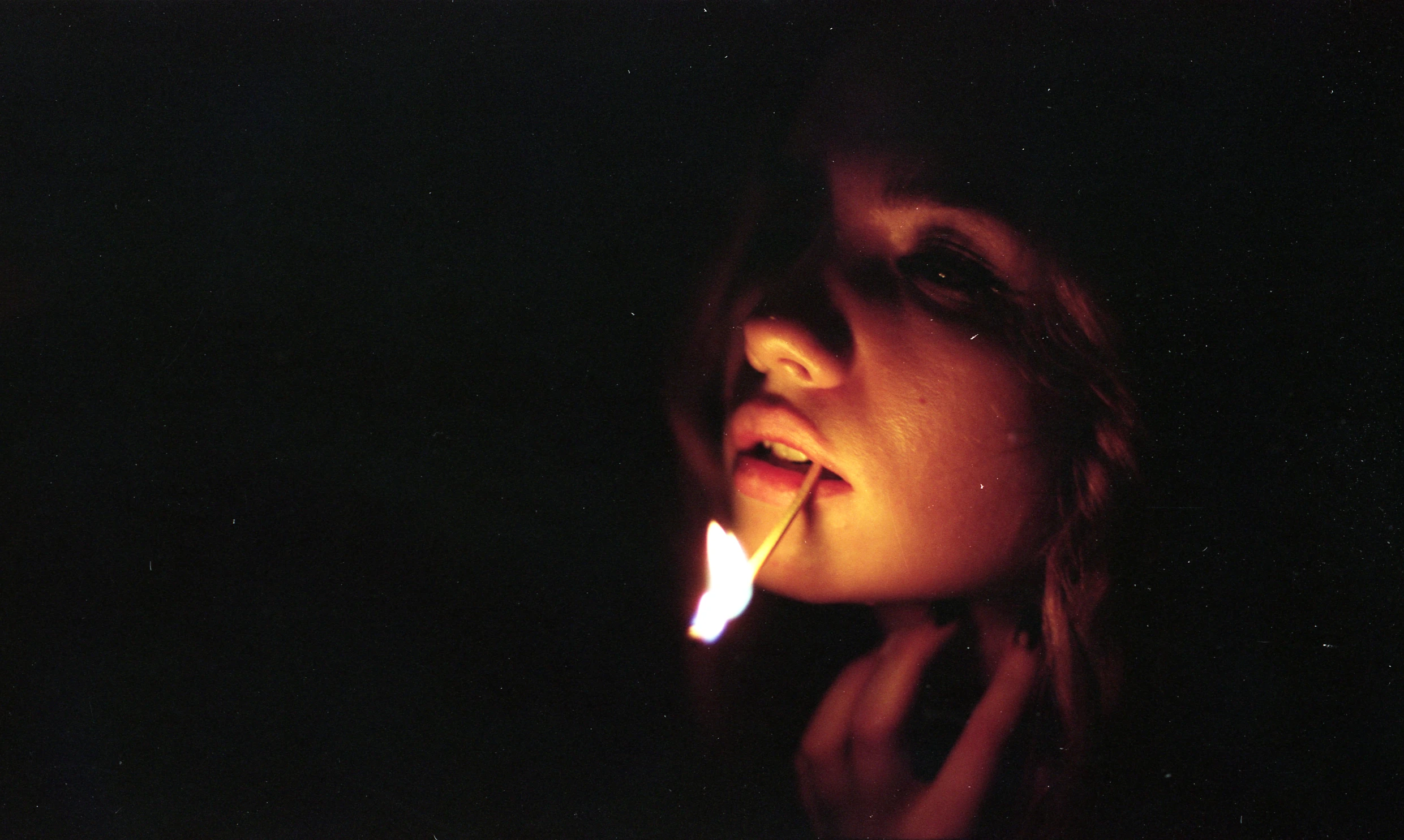 a close up of a person with a lite cigarette