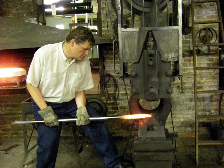 a man bending over and looking at the  metal