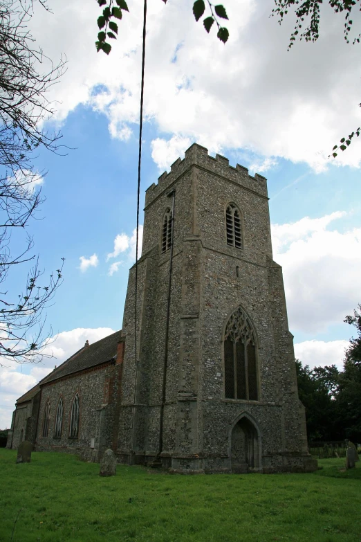 a tall brick building with windows sitting in the middle of a field