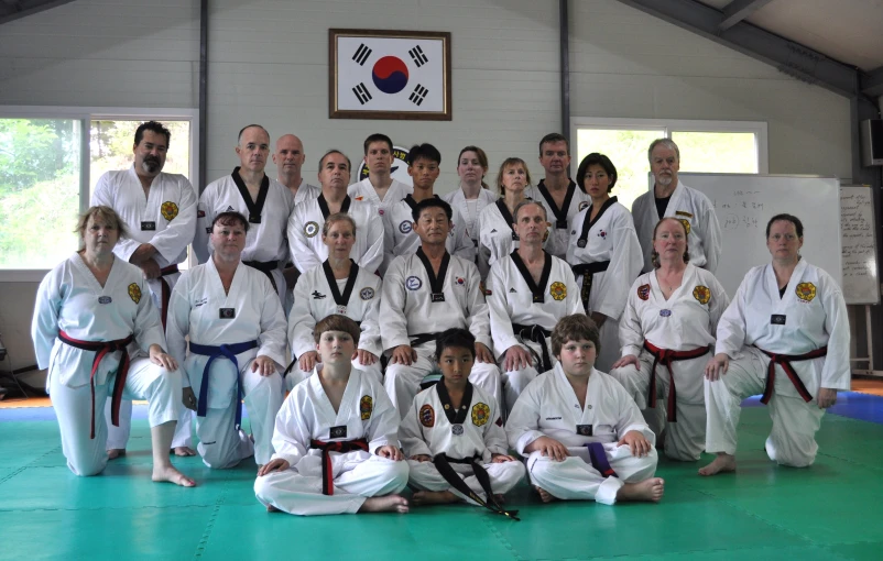 people posing for a group pograph in white jij karate uniforms