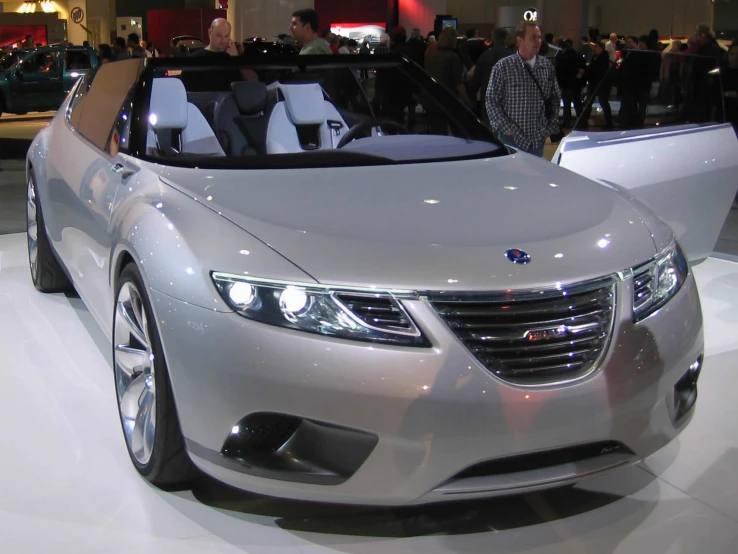 a silver convertible is parked inside of a building