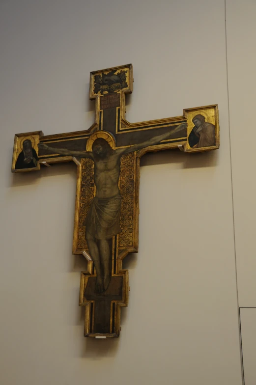 the golden cross is adorned with pictures of jesus christ on it