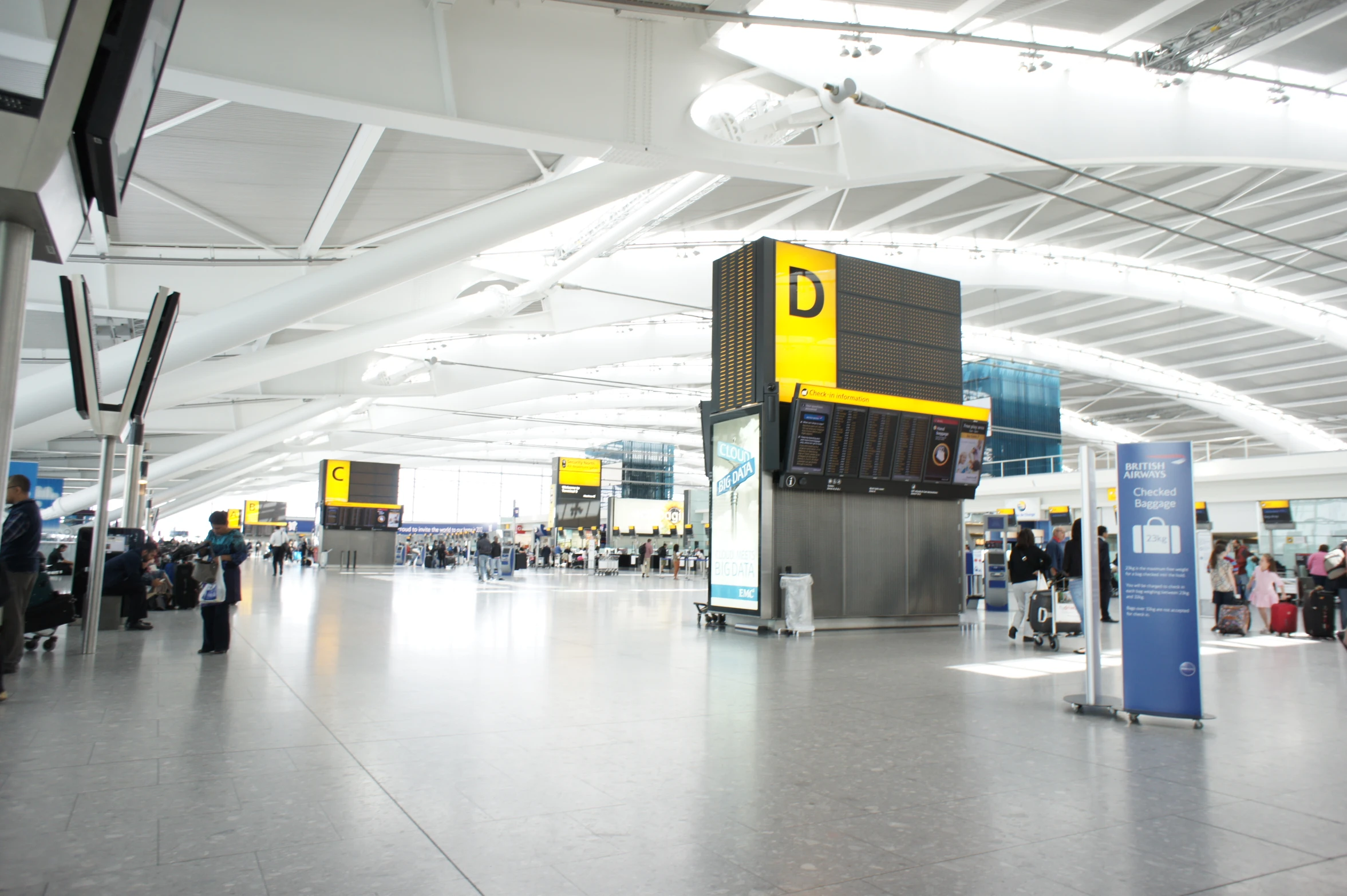 an airport has many people walking around the terminal area