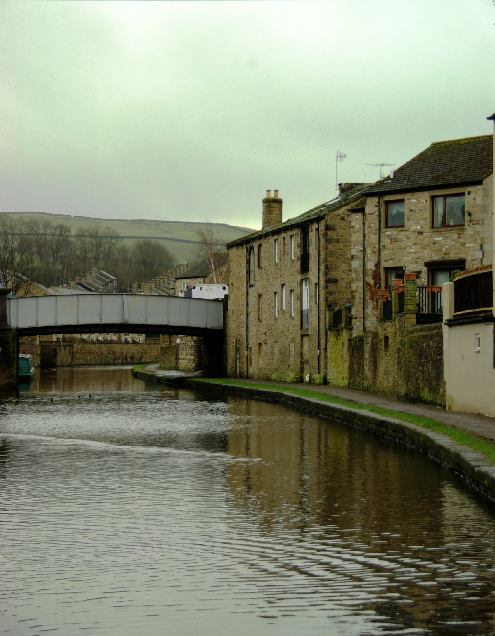 a river running under a bridge with buildings next to it