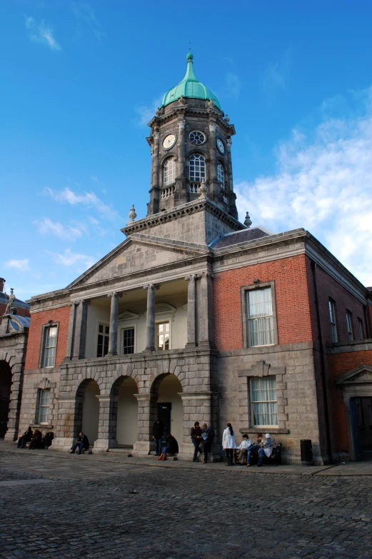 people walk around in front of a historic building