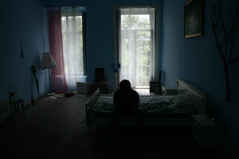 a person sitting on a bed at night