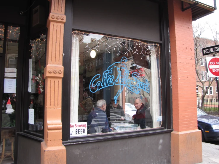 a couple of people standing outside of a store window