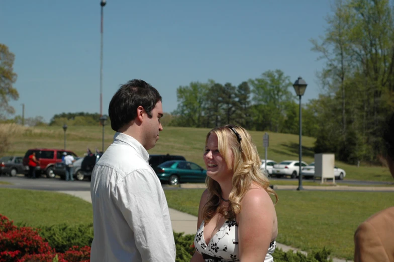 a woman and man talking on the sidewalk