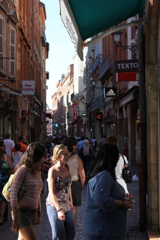 people are gathered in a crowded street near some buildings