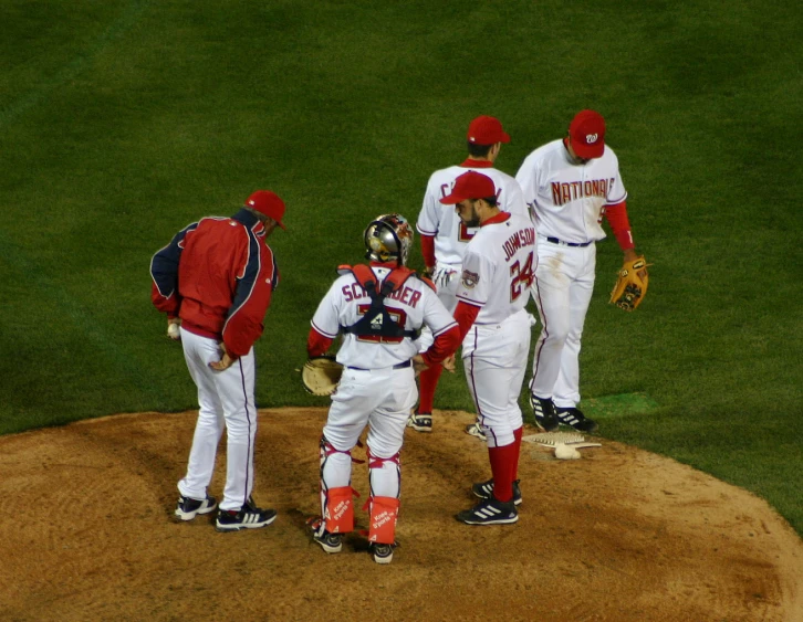 three baseball players standing on top of a baseball field