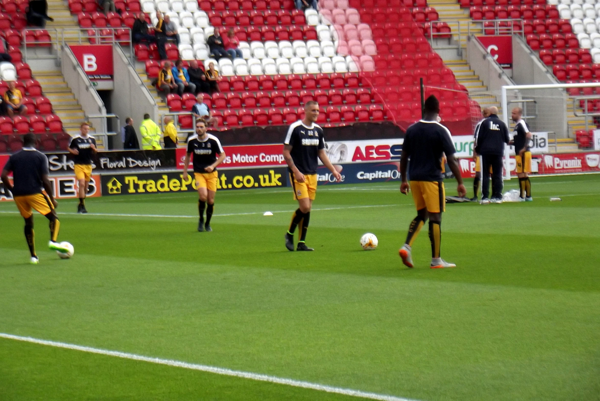 two teams playing soccer in an empty stadium