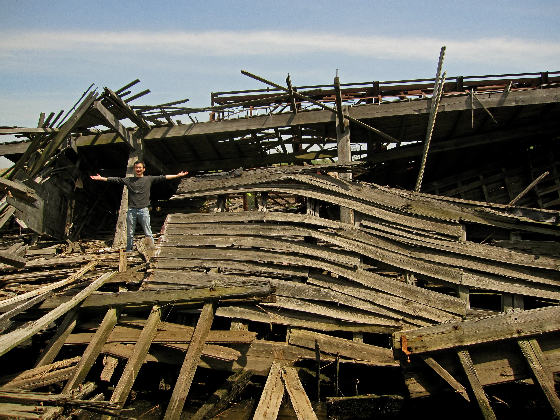 a man standing on top of an old wooden boat