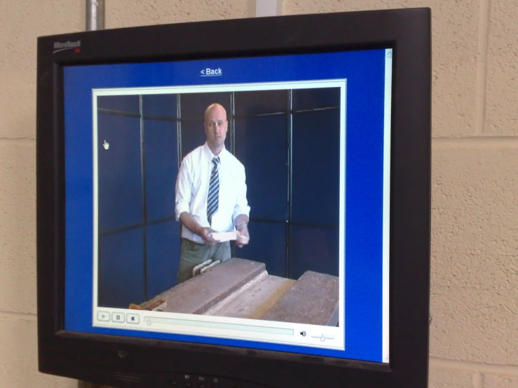 there is a television showing a man in front of a box
