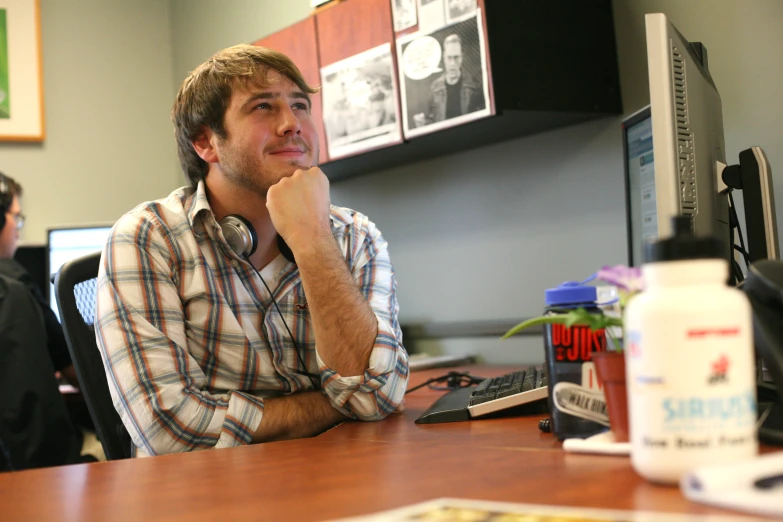 two men sitting at a desk in an office