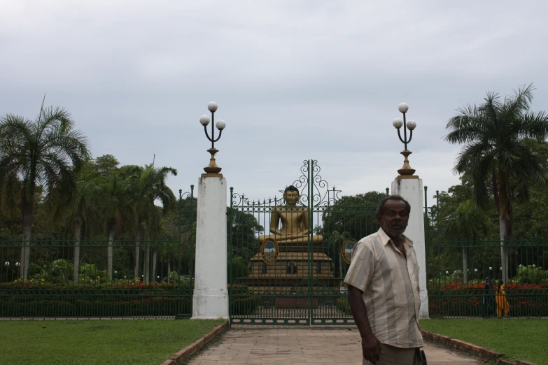 a man standing in front of two white pillars with gold and silver decorations