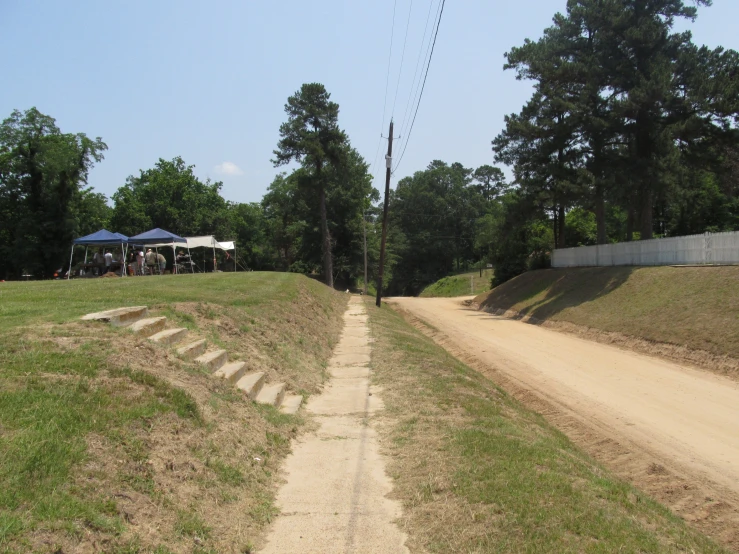 a dirt road that is next to some trees