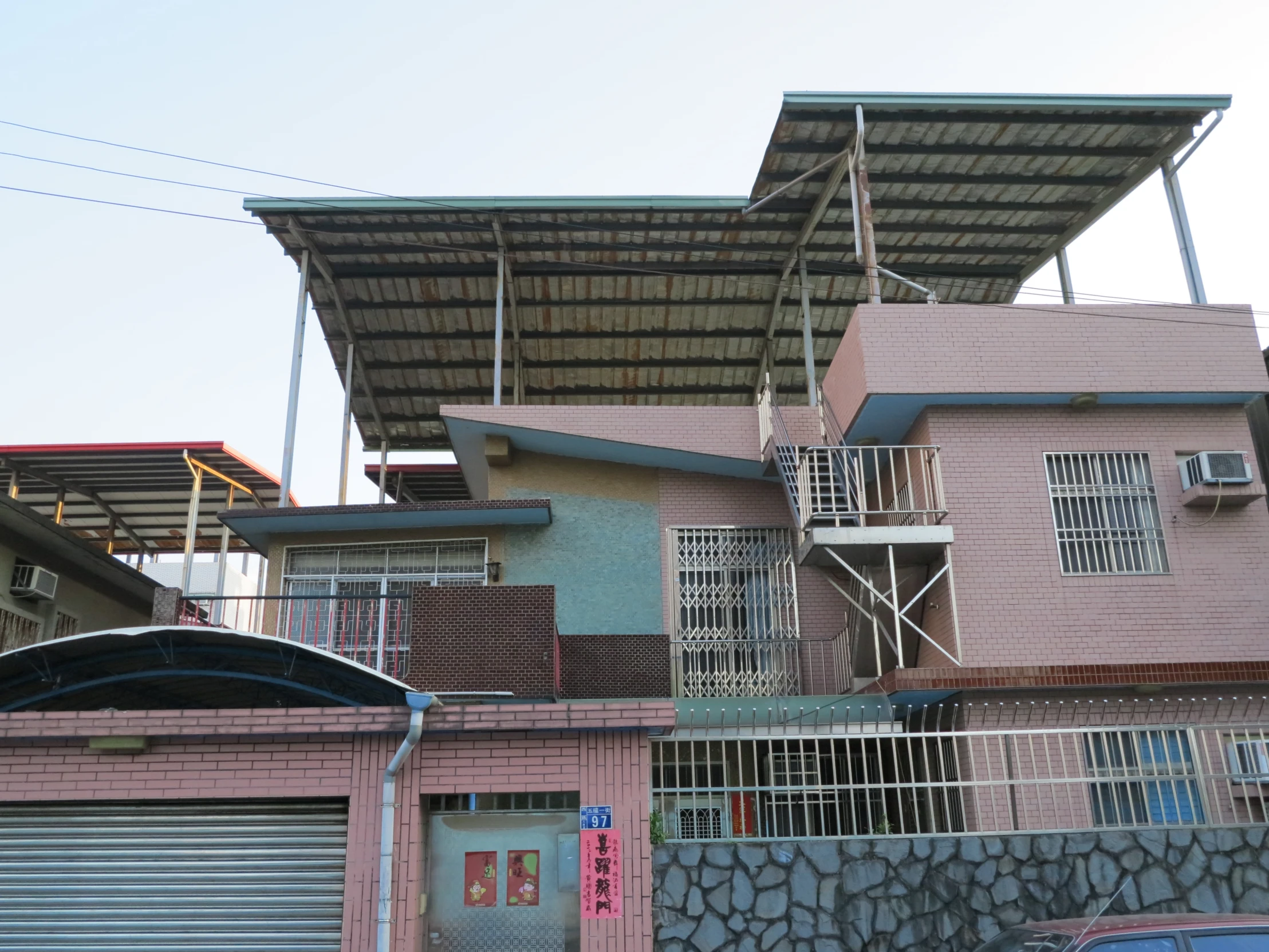 three houses with large wooden roof structures above them