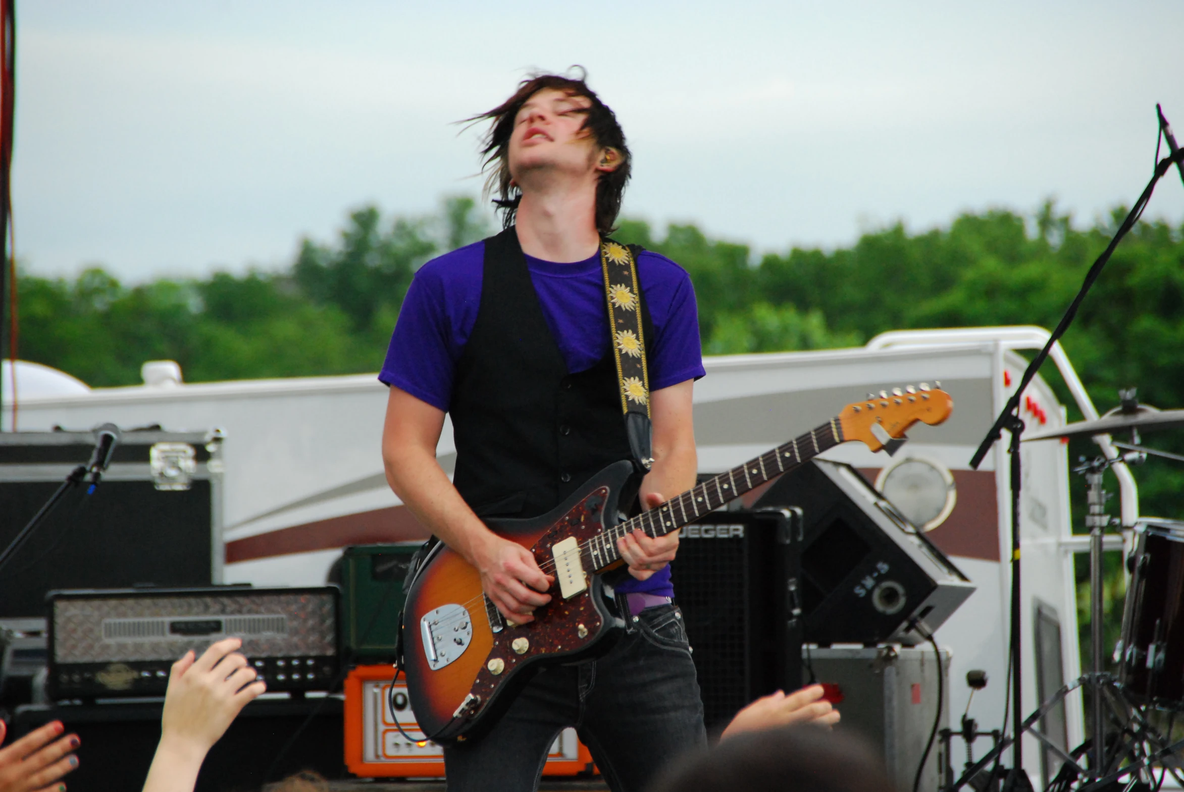 a man standing next to a guitar at a concert