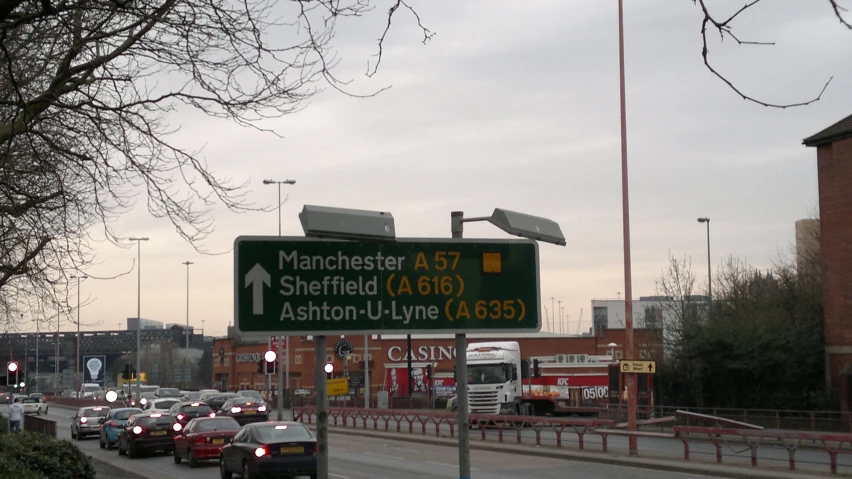 a green sign points traffic towards the left