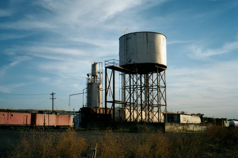 an old water tower sitting in the middle of a field