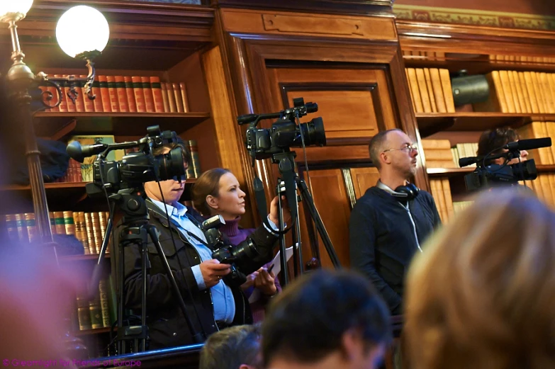 a group of people in front of a television camera on some kind of tripod