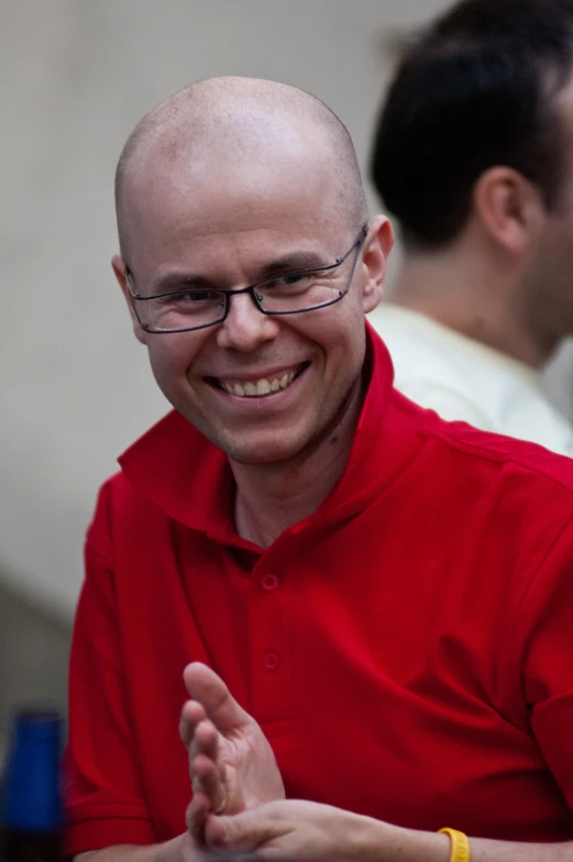 a man smiling while looking at his cell phone