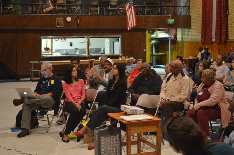 the audience watches a panel of people discuss and take notes