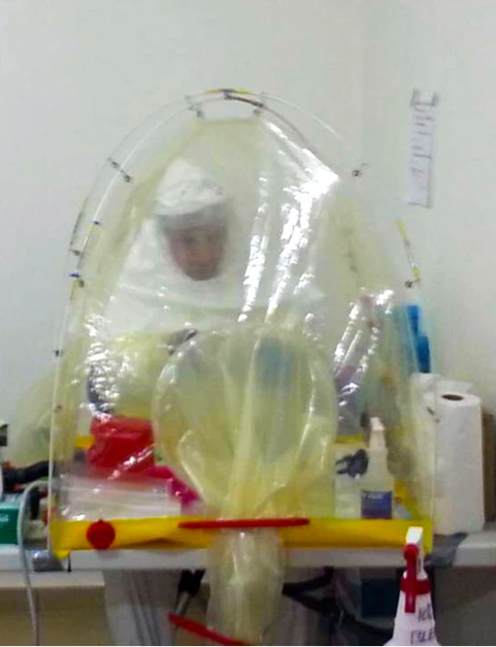 a man in a white uniform sitting at a table next to medical equipment