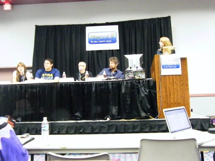 a group of people sitting on chairs at a table talking