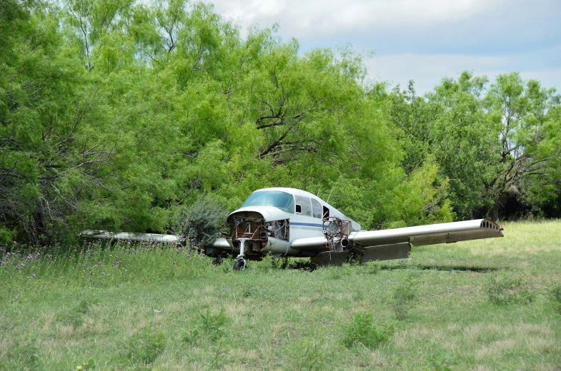 a vintage airplane sitting in the middle of a grassy field