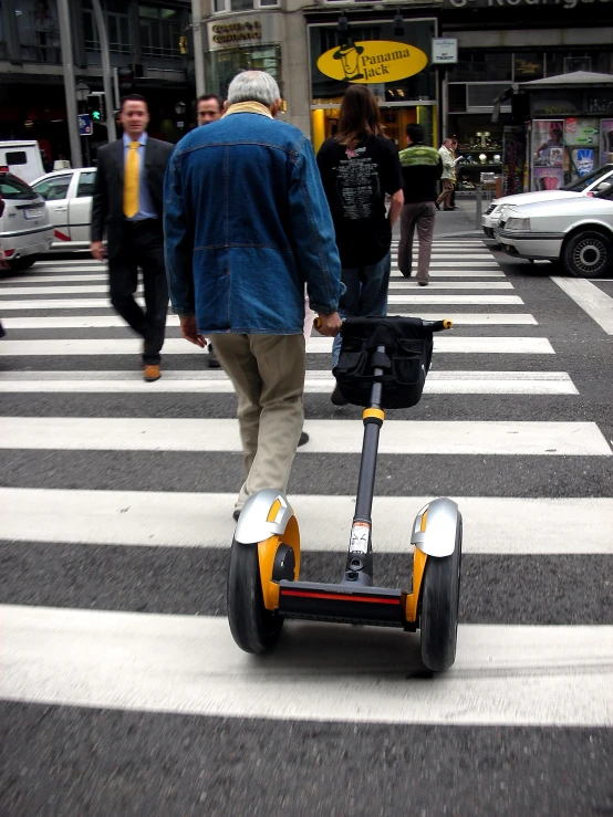 a man riding an electric scooter on a street