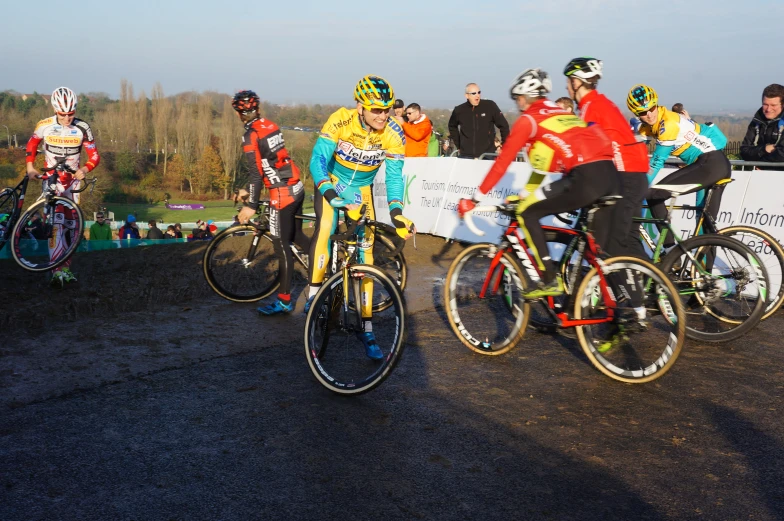 a group of cyclists racing on top of dirt